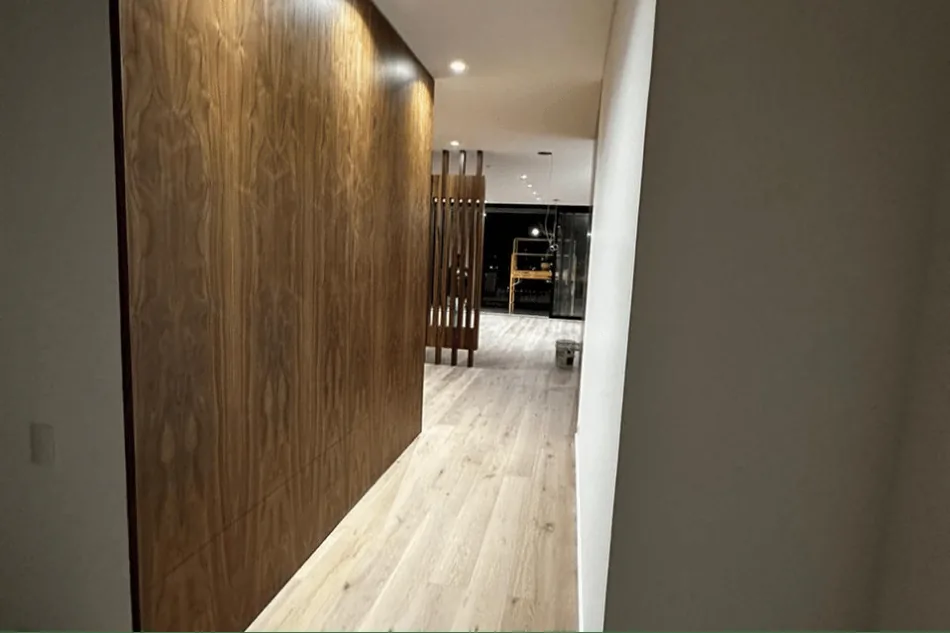 Corredor terminado con revestimiento de madera y piso instalado.