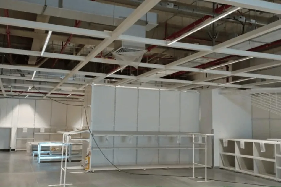 Interior comercial terminado con cielo raso y luminarias instaladas.