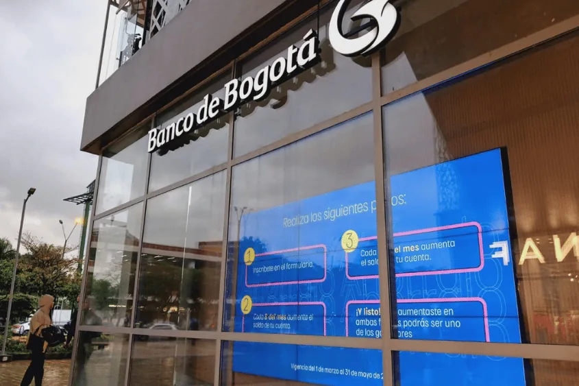 Fachada de la sucursal del Banco de Bogotu00e1 con pantallas informativas encendidas.