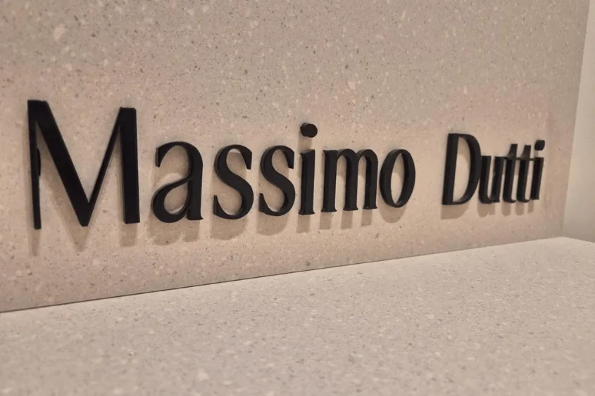 Ru00f3tulo de Massimo Dutti sobre el paramento de piedra de la fachada.
