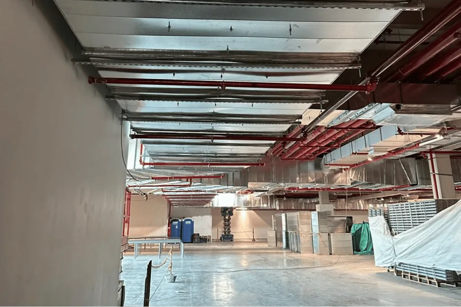Interior comercial durante obra con instalaciones tu00e9cnicas a la vista.